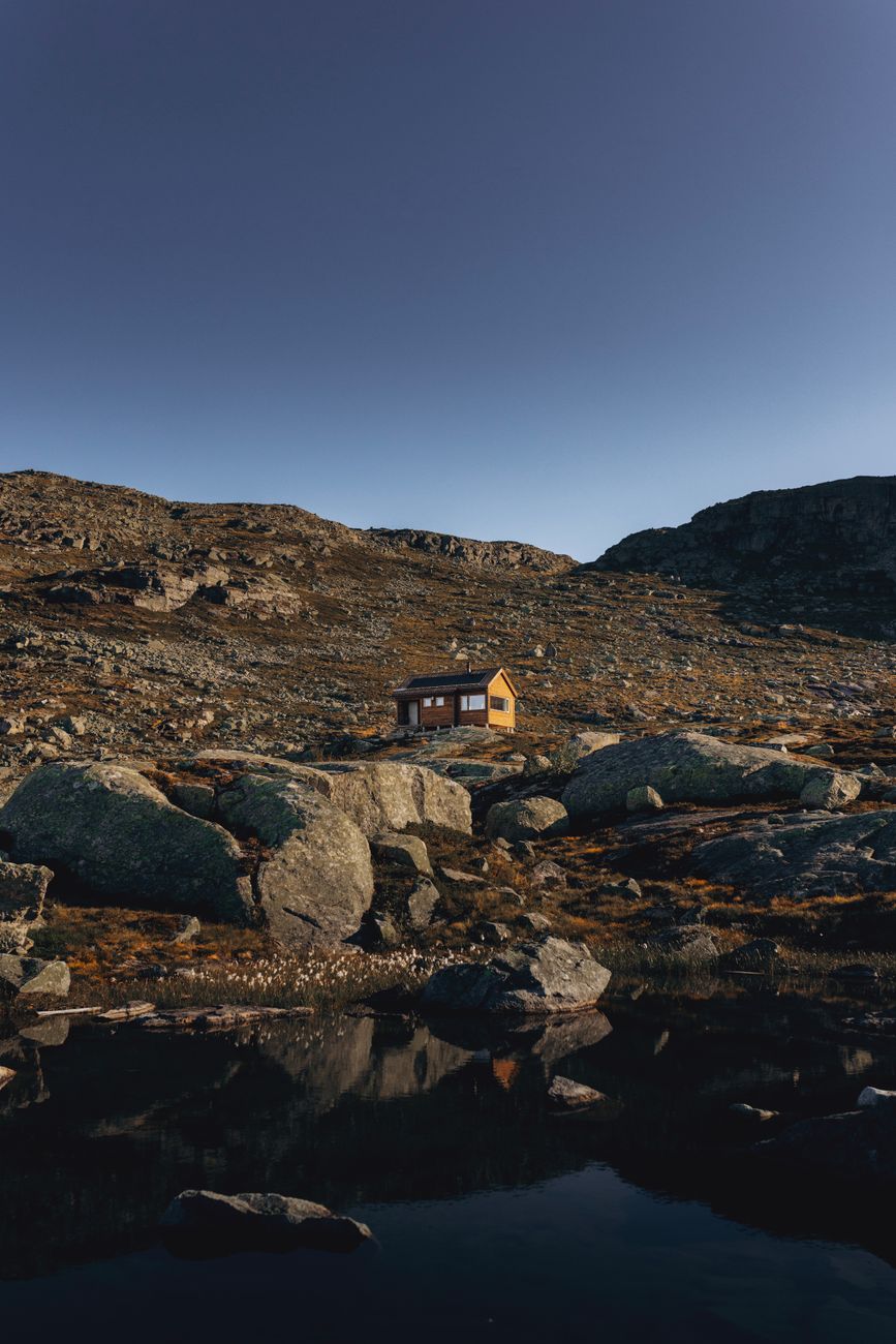 Modern black timber cabin standing over coastal rocks in Norway